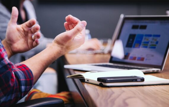 Consultant gesturing while presenting during a business meeting