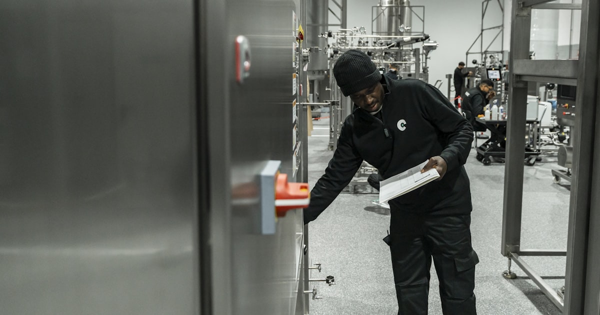 Auditor with a clipboard inspecting equipment inside a production facility